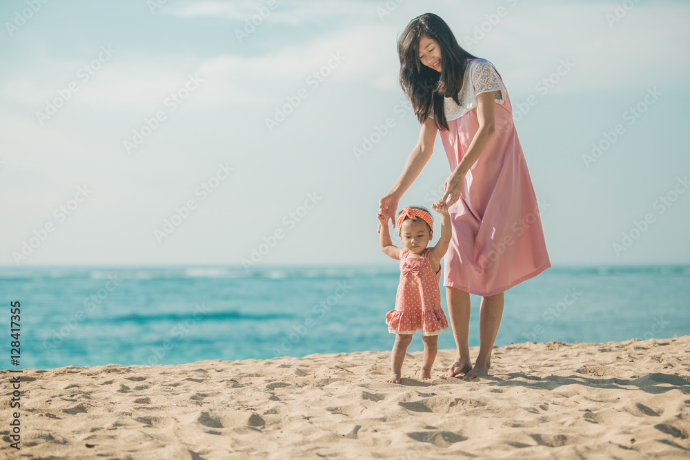 mother is teaching her daughter walks on the beach mother is teaching her daughter walks on the beach