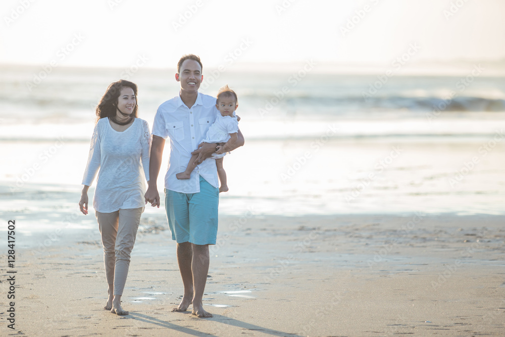 happy family of three enjoying summer at the beach