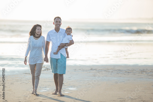 happy family of three enjoying summer at the beach