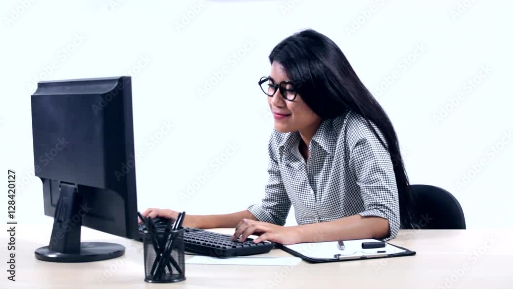 Happy Asian businesswoman working with a computer on the table and expressing her success Happy Asian businesswoman working with a computer on the table and expressing her success