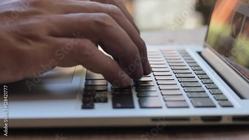 Closeup of business man hand typing on laptop keyboard