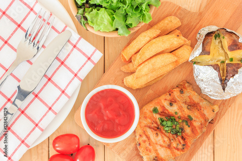 Grilled meat steak serve with tomato sauce, Mashed Potatoes, french fries and vegetable salad, isolated on wooden background, Closed up