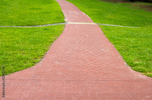 Red stone walking path in a grass field