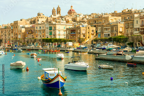beautiful boats in Valletta harbour with cityscape on the background photo