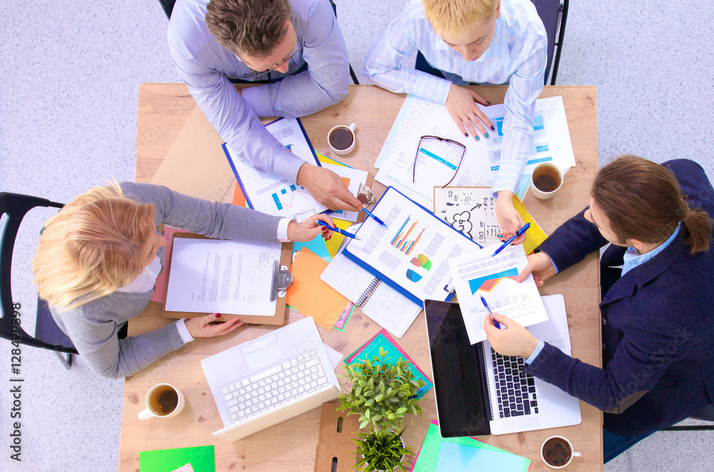 Image of business partners discussing documents and ideas at meeting Image of business partners discussing documents and ideas at meeting