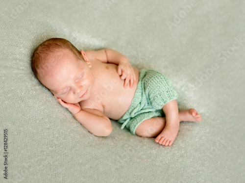 sleeping baby with hand under his head and crossed legs