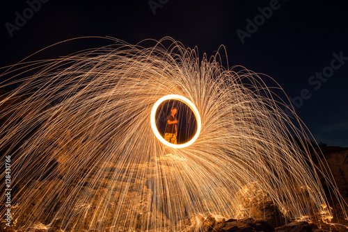 Showers of hot glowing sparks from spinning steel wool on the rock