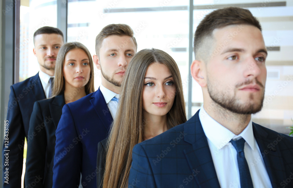 Happy smiling business team standing in a row at office Happy smiling business team standing in a row at office