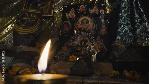 A candle burning in front of the image of Goddess Kali in indian ashram photo