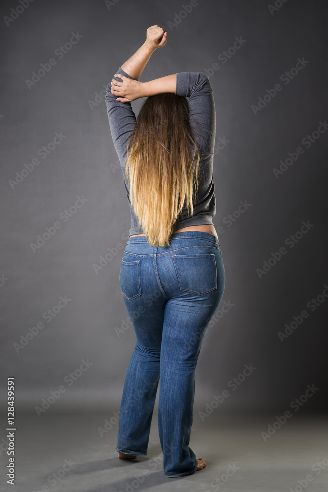 Plus size model in blue jeans, xxl woman on gray studio background foto de  Stock | Adobe Stock