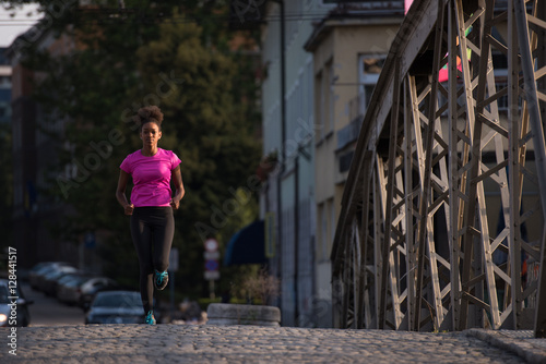 african american woman running across the bridge