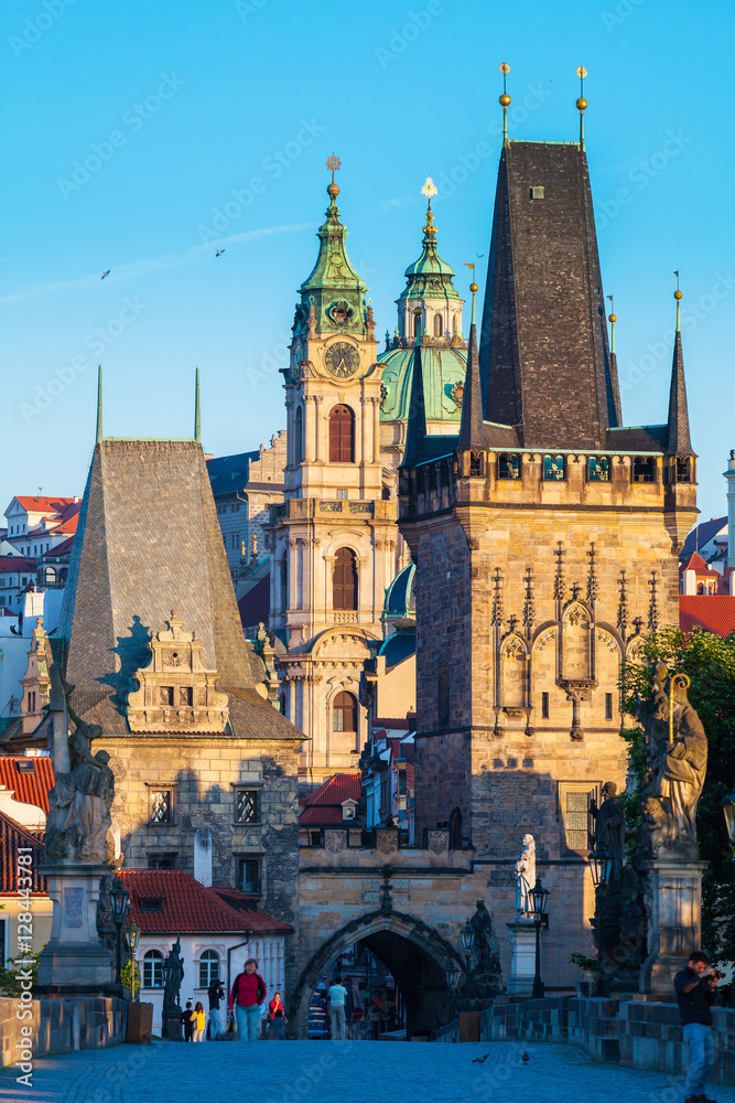 Fototapeta premium Prague, Czech Republic. Charles Bridge with its statuette at sunrise, Old Town Bridge Tower in the background.