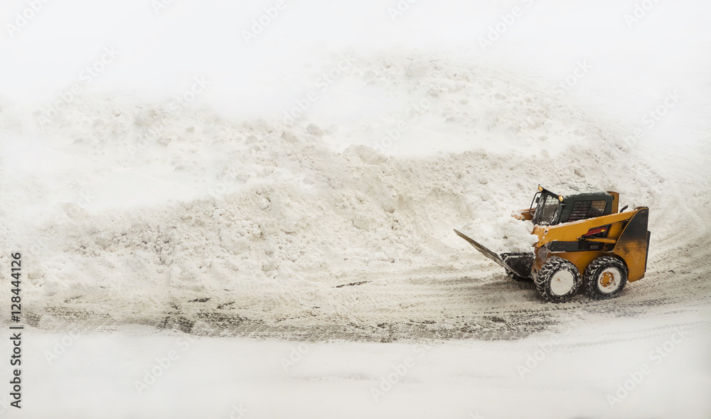 Yellow snow removing bulldozer near big snow piles Yellow snow removing bulldozer near big snow piles
