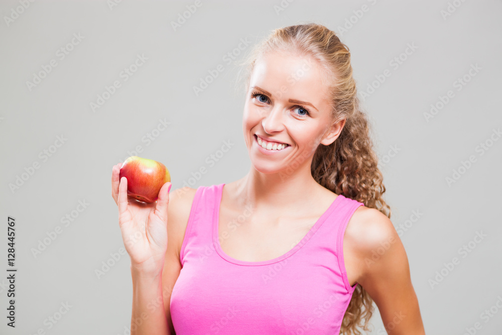 Studio shot image of young sporty woman who is holding an apple. Studio shot image of young sporty woman who is holding an apple.
