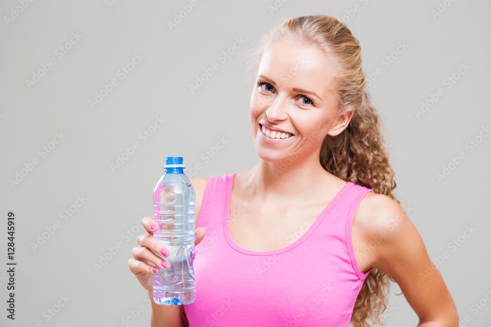 Studio shot image of young sporty woman who is holding water bottle. Studio shot image of young sporty woman who is holding water bottle.