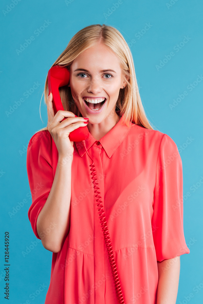 Happy blonde woman talking on red phone Happy blonde woman talking on red phone