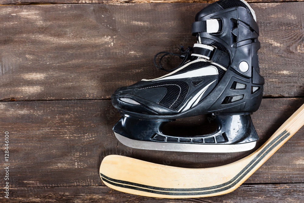 Obraz premium Overhead view of hockey stick and ice skates on old rustic woode