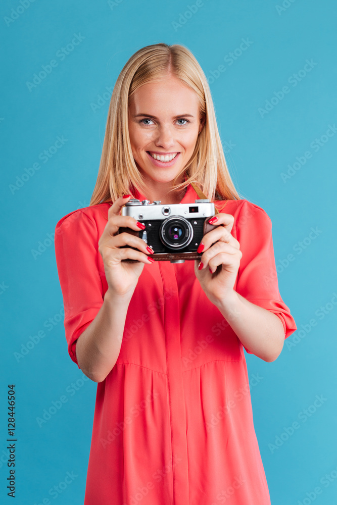 Portrait of a smiling blonde woman holding retro camera Portrait of a smiling blonde woman holding retro camera
