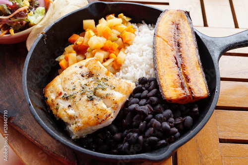 Traditional Costa Rican Casado meal with rice, beans, plantains and fish photo