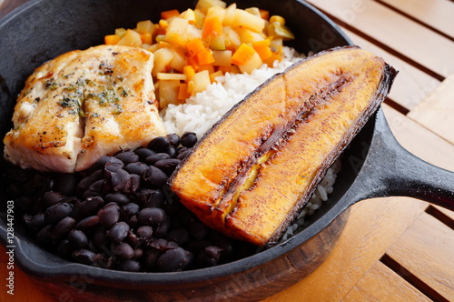 Traditional Costa Rican Casado meal with rice, beans, plantains and fish