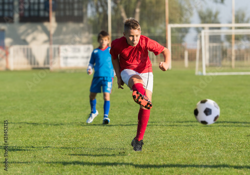 Boy kicking soccer ball © Dusan Kostic