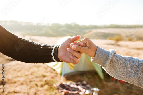 Couple holding hands near the tent