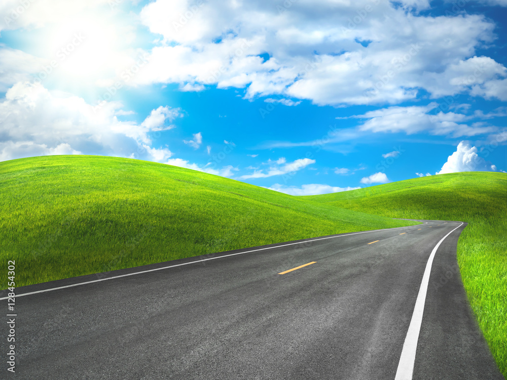 Fototapeta premium asphalt road through the green hill with beautiful sky