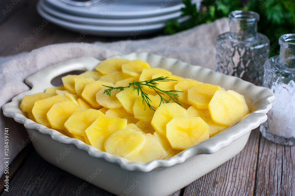 Raw potato gratin in the cooking process, horizontal Raw potato gratin in the cooking process, horizontal