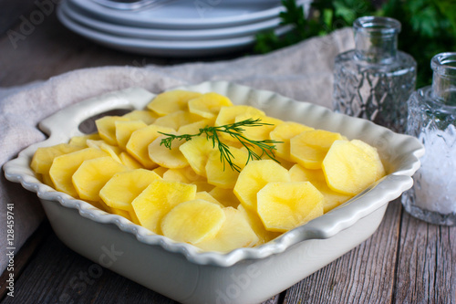 Raw potato gratin in the cooking process, horizontal