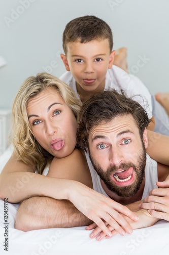 Portrait of parents and son lying on bed and having fun