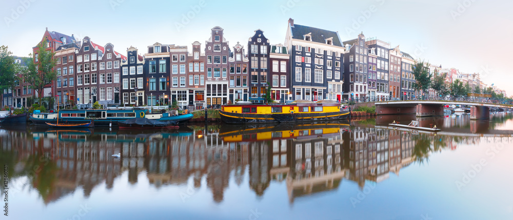 Naklejka premium Panorama of Amsterdam canal Singel with typical dutch houses, bridge and houseboats during morning blue hour, Holland, Netherlands.