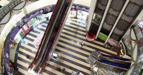 People move up and down the escalators and they move up and down on the elevators at the mall, timelaps
 photo