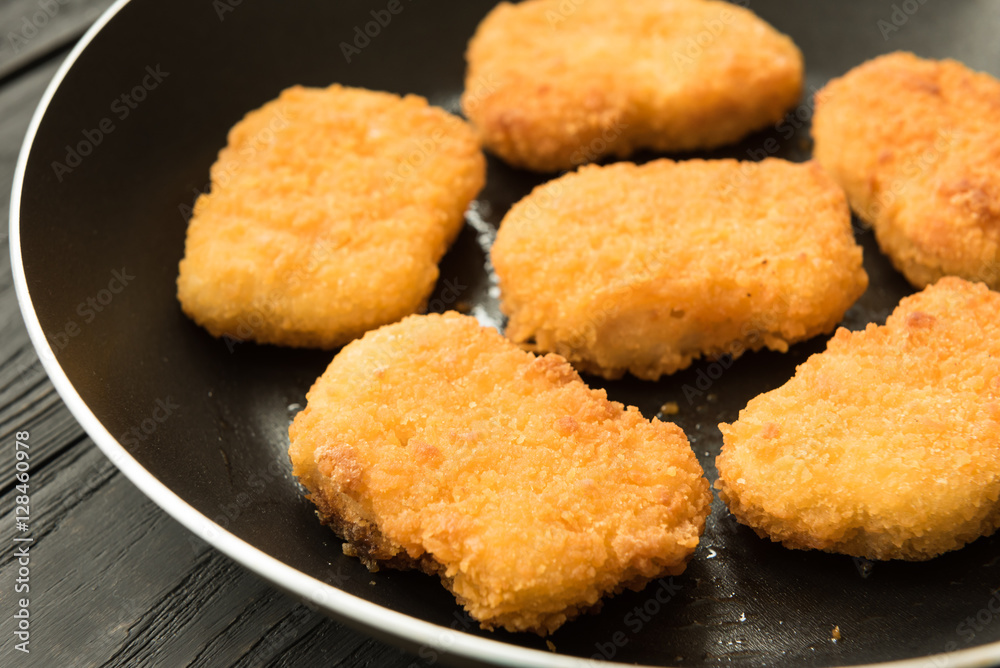 Cooked chicken nuggets in frying-pan