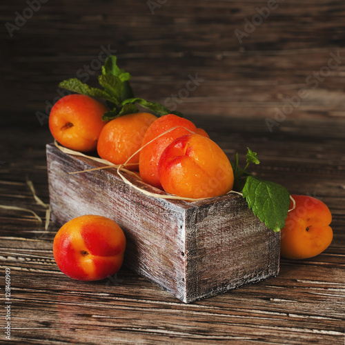 Fresh apricots in small wooden box, selective focus, top view