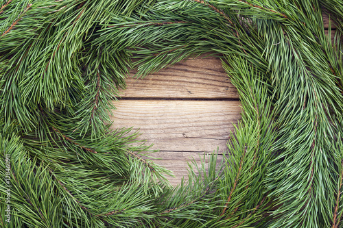 Round frame made of Christmas pine tree branches on old wooden