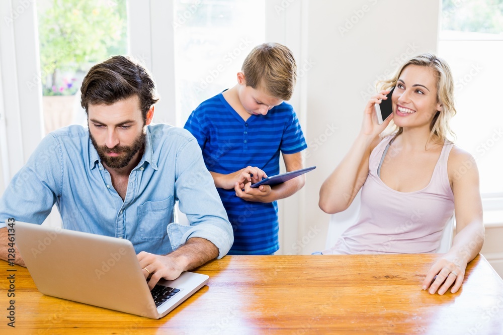 Parents and son using a laptop, tablet and phone Parents and son using a laptop, tablet and phone