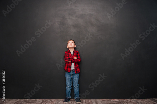 Image of pretty little boy standing over chalkboard