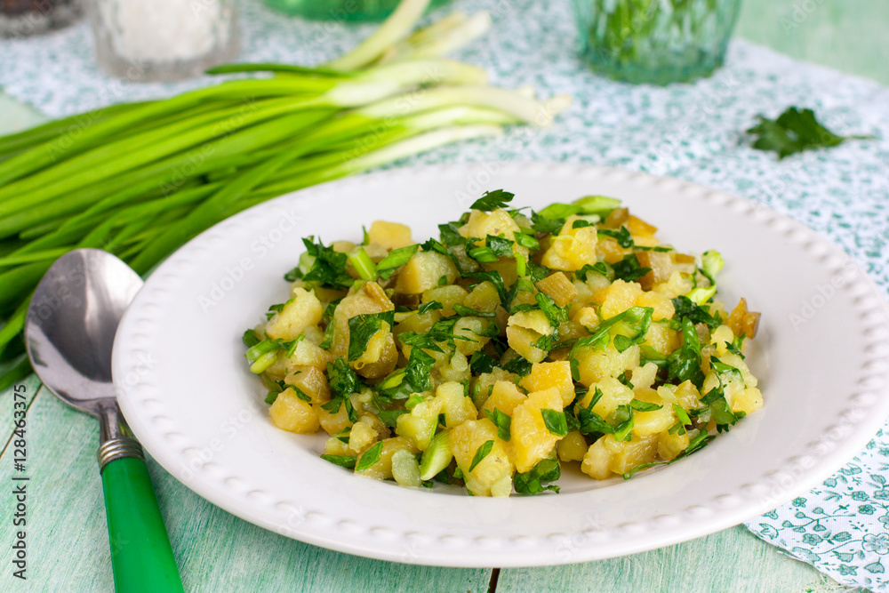 Potato salad on a white plate with fresh herbs Potato salad on a white plate with fresh herbs
