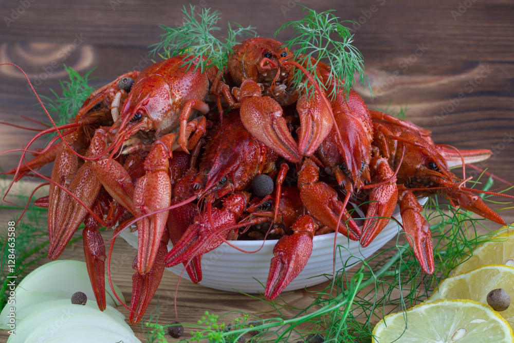 Red boiled crayfishes, fennel, onions, lemon on wooden backgroun Red boiled crayfishes, fennel, onions, lemon on wooden backgroun