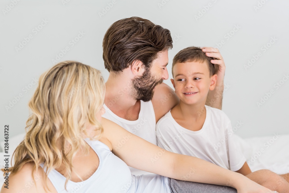 Parents and son sitting on bed in bedroom Parents and son sitting on bed in bedroom