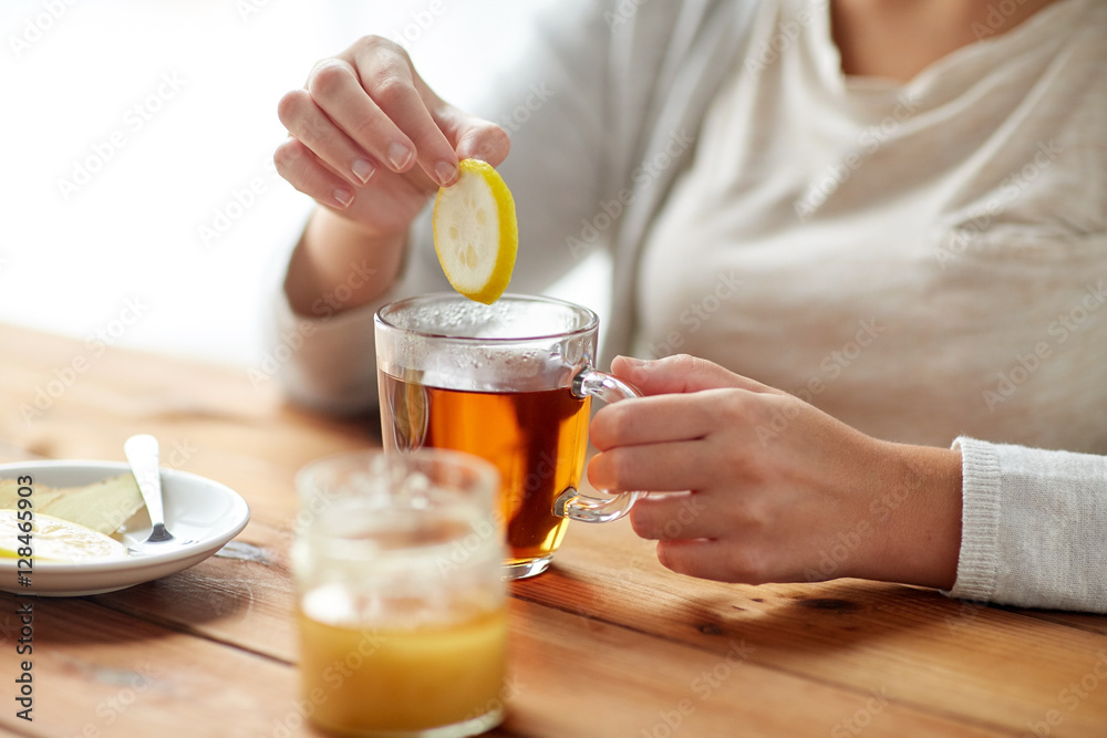 close up of ill woman drinking tea with lemon close up of ill woman drinking tea with lemon