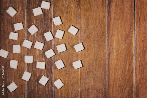 White sugar cubes on wooden background. Copy space. Top view