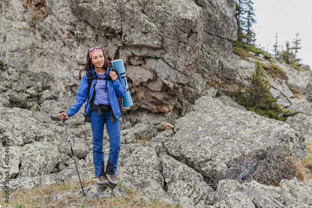 Woman hiker is trekking in Mountains among field of stones and rocks. Trail to high peak Woman hiker is trekking in Mountains among field of stones and rocks. Trail to high peak
