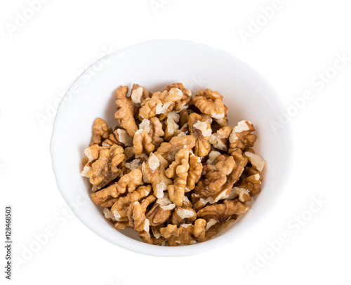 Pile of walnuts in white bowl.