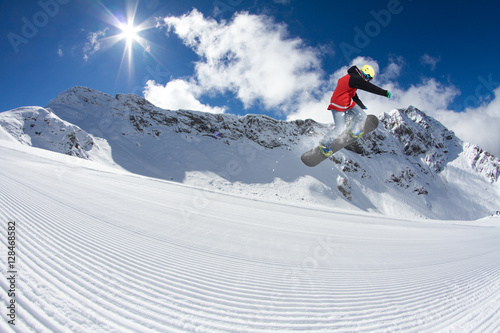 Fotografie Snowboard rider jumping on mountains