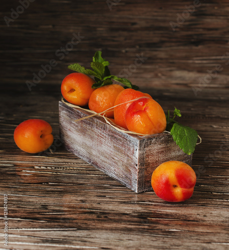 Fresh apricots in small wooden box, selective focus, top view