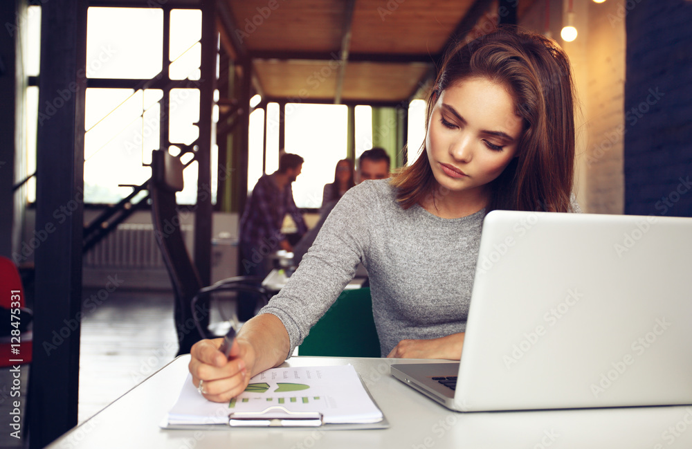 Portrait of a serious businesswoman using laptop in office