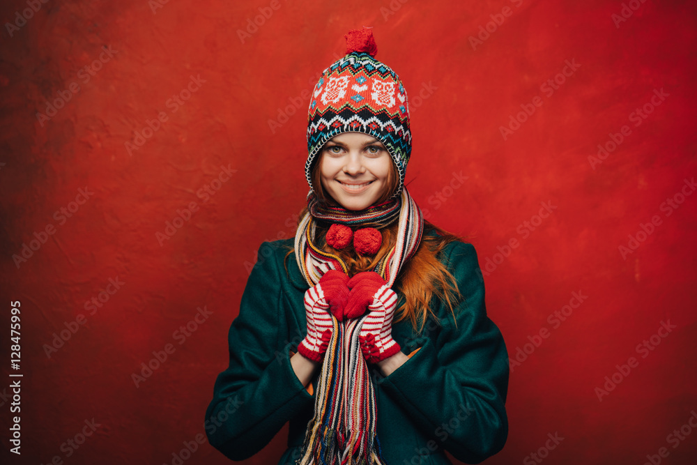 Pretty smiling woman in a funny hat on bright background
