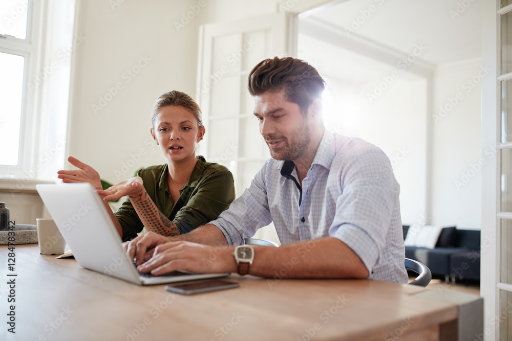 Young man and woman at home using laptop Young man and woman at home using laptop