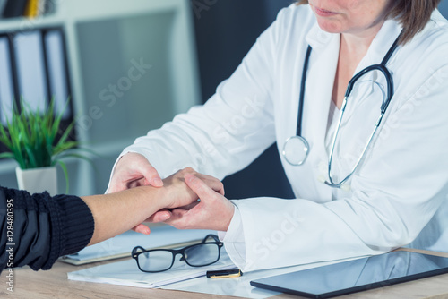 Female patient at orthopedic doctor medical exam for wrist injur photo